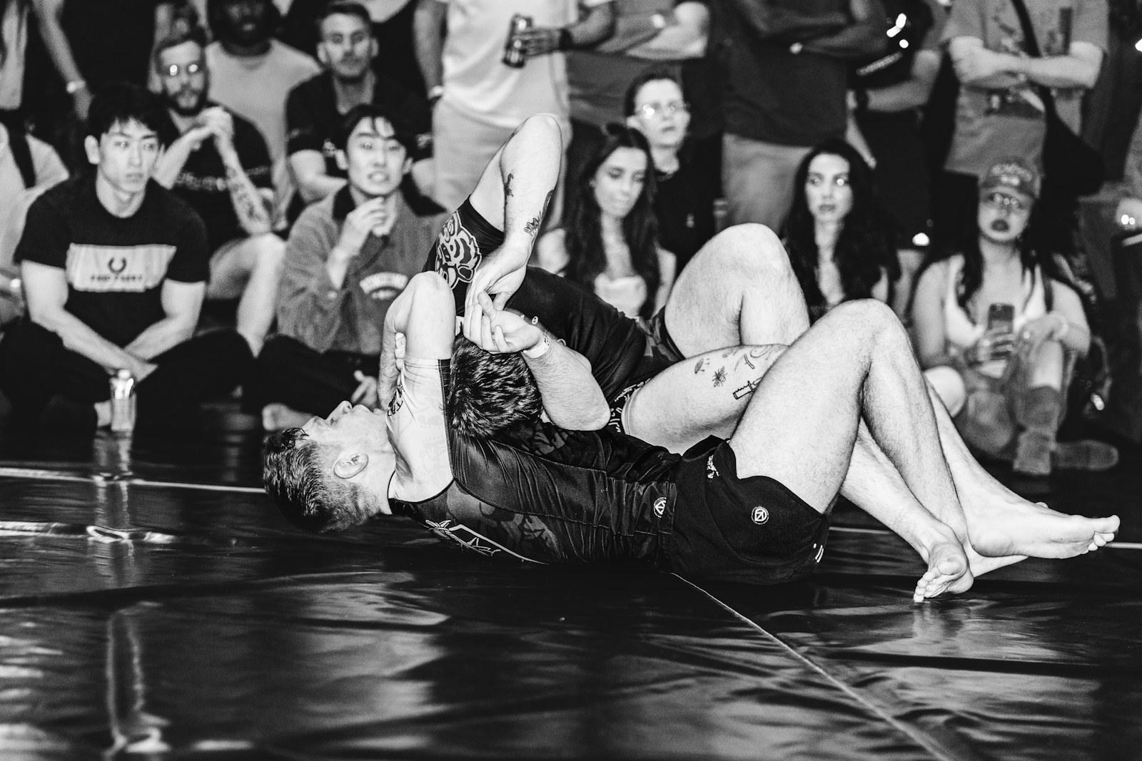 Atletas em uma disputa de grappling diante do público